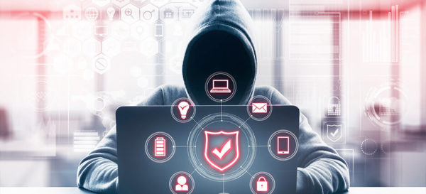 Hacker mit Kapuzenpullover sitzt vor Laptop