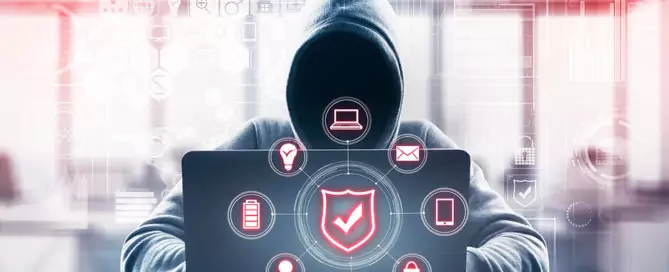 Hacker mit Kapuzenpullover sitzt vor Laptop