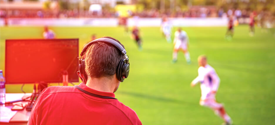 Kommentator sitzt im Fußballstadion - Sportjournalismus