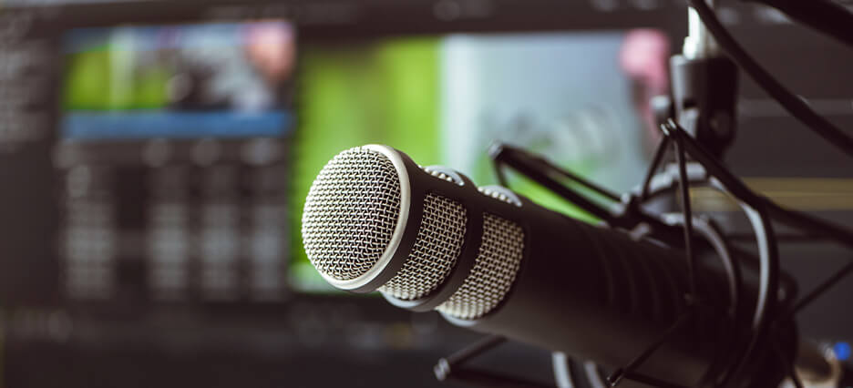 Mikrofon vor Bildschirmen signalisiert die Arbeit eines Sportkommentators